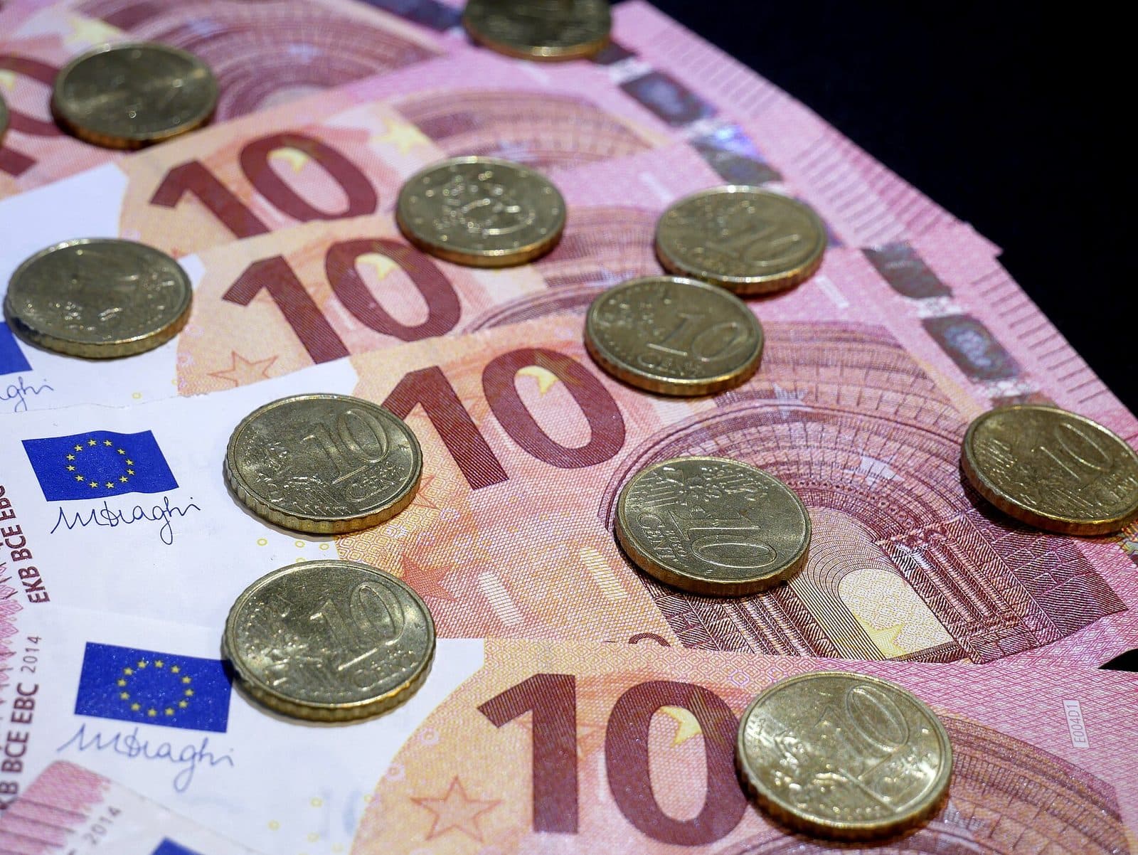 Desaťeurové bankovky a desaťcentové mince rozložené na stole
